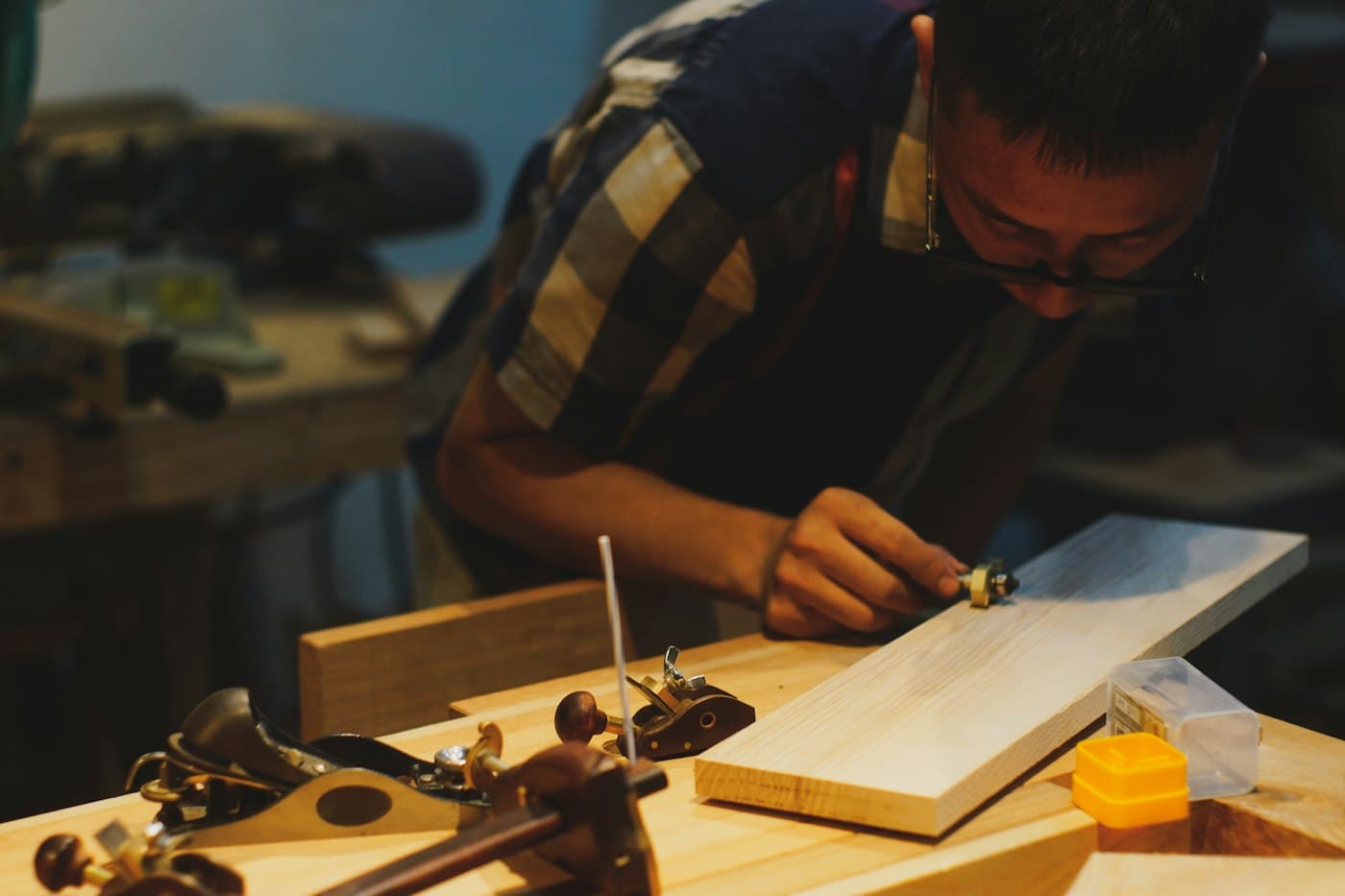 Un menuisier raboteur une planche de bois dans son atelier